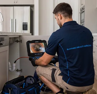 Plumber clearing a blocked toilet in a Engadine bathroom